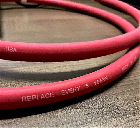 Red rubber water supply hose. Replace every 5 years to prevent leaks and water damage.