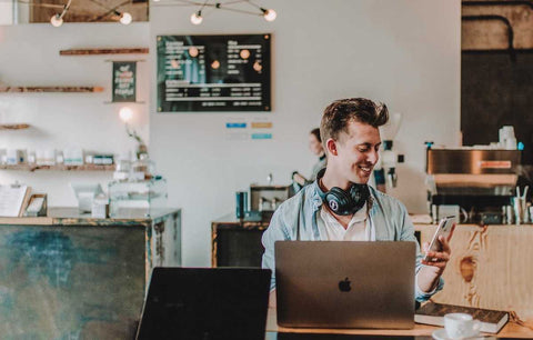 Male digital nomad in cafe using wifi to call family with his US number using Google Voice