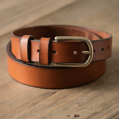 A photo showcasing a rich brown leather belt with a smooth, even surface and a classic brass buckle.