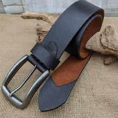 A close-up photo of a sleek black leather belt with a visible natural grain texture and a simple, polished buckle.