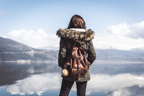 Woman wearing an italian leather backpack looking out over a lake