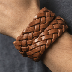 Braided leather belt in rich brown color with an intricate woven pattern and a polished silver buckle, offering a sophisticated look for casual or dressy occasions.