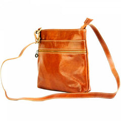 Tan Leather crossbody bag with adjustable strap and gold fastenings set against a white background