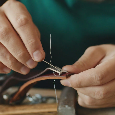 Image of a person adding a buckle to a leather belt