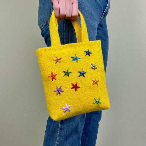 A decorated yellow tote bag for carrying items to school