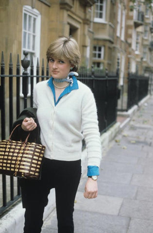 A shy Diana Spencer wearing a white jumper and carrying a leather tote bag