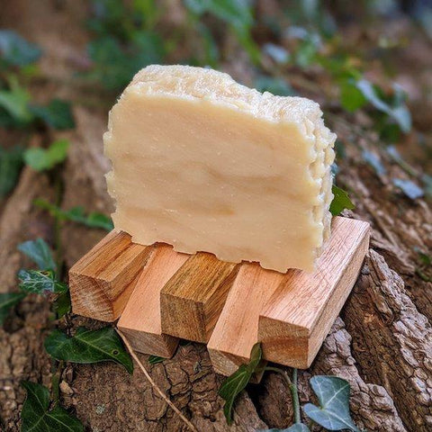 Our best selling honey soap sitting on a recycled wood soap dish