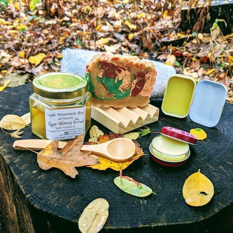 The Nature Walk gift set is inspired by the beauty of the fall. It contains a rosemary soap, scented with essential oil, and decorated with mineral mica and volcanic clay forming swirls in ochre, red, green and beige. The beech wood soap dish will help extend the life of your soap by allowing it to dry between uses. The thick and soft washcloth will intensify the creamy lather leaving your skin moisturized. The honey and vitamin E scrub will gently remove dead cells and leave your skin revitalized. The bamboo spoon will allow you to scoop out as much as you need. The beeswax lip balm will restore your lips after being outdoors, and the dandelion infused salve will soothe your dry hands after the fall gardening and wilderness adventures.
