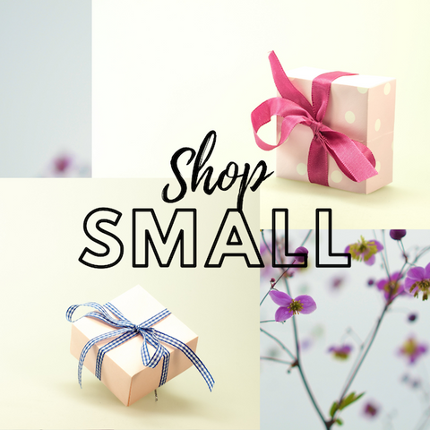 Shop Small reads in the middle of an image with two gift boxes over a background of ethereal purple flowers.