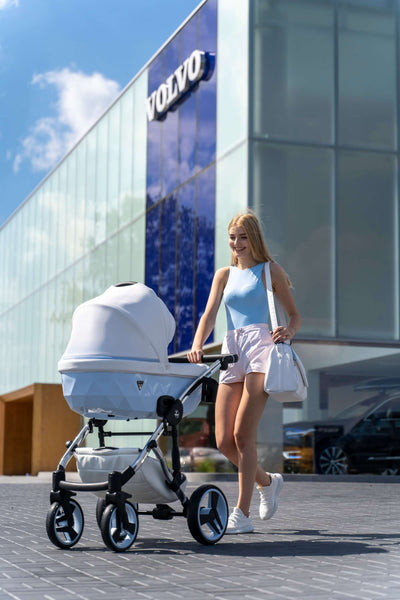 A woman pushing the Junama Diamond Stroller Candy V3 in White + Blue