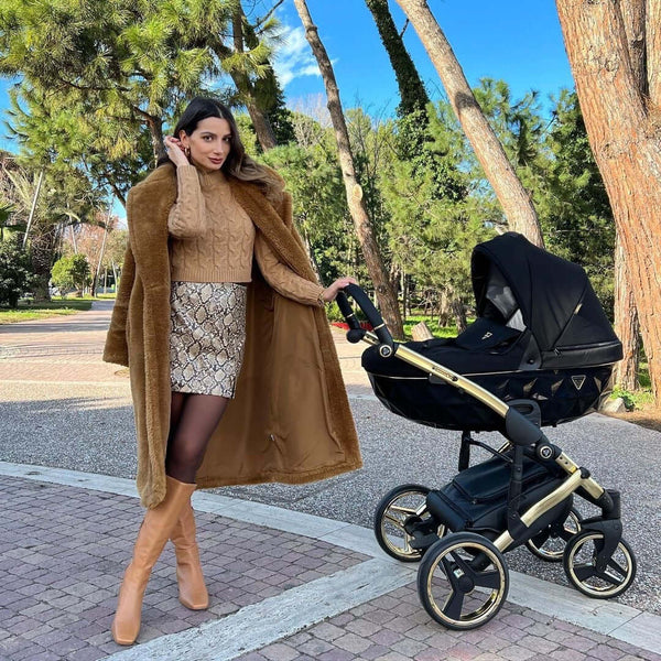 A woman in the park with Junama Diamond Stroller S-Line V3 in Black with Golden Frame