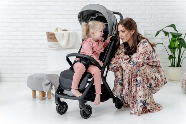 A woman with kid inside the Espiro Nox Stroller in Grey