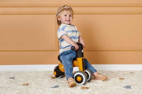 A toddler riding his Kinderkraft Balance Bike MINIBI
