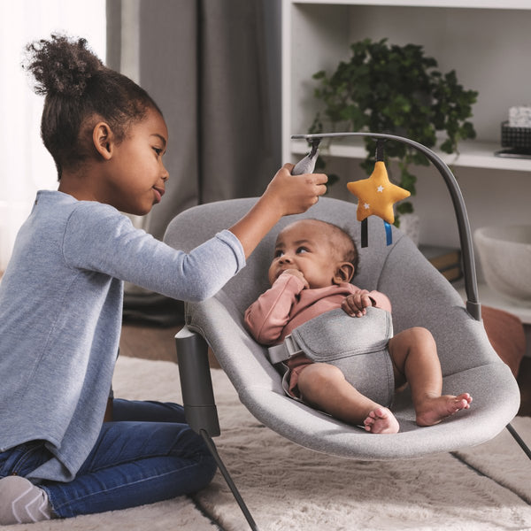 Child playing with baby in Kinderkraft Bouncer CALMEE