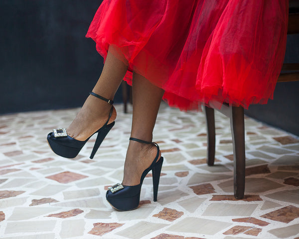 Ezinne Chinkata wearing a red skirt and black high healed shoes by The Ladymaker