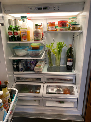 Celery stalks in a glass of water in a fridge