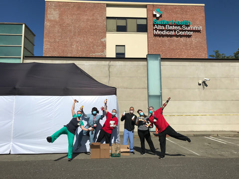 A team of nurses & doctors posing with a few boxes of donated bars & nutrition.