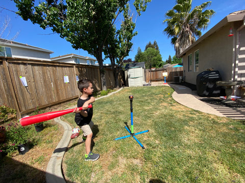 Aiden hitting a small t with a baseball on it.