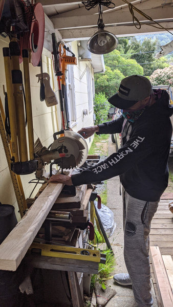 Austen sawing the wood at an angle.