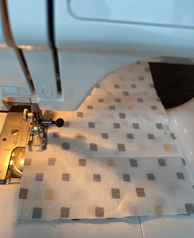 Sewing machine sewing fabric.