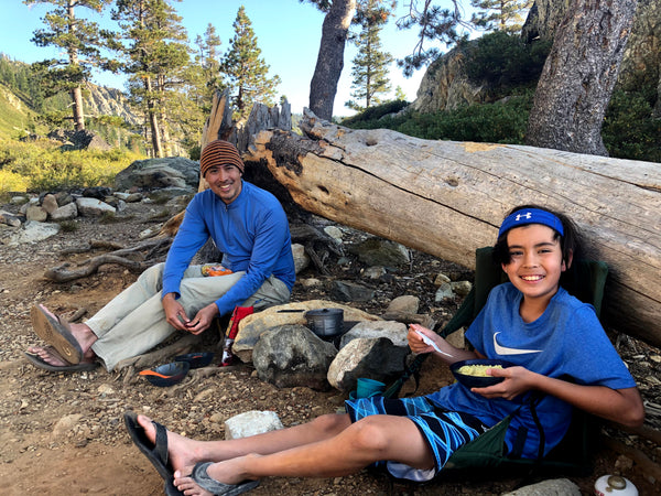 Susan's family sitting on a tree eating their noodles