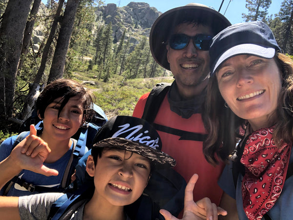 Susan with her husband and two kids taking a selfi.