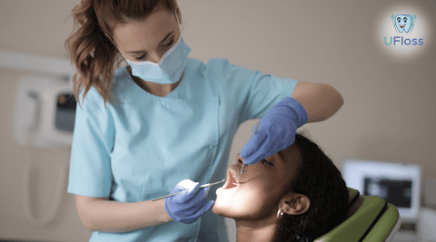 Teenage girl in dental chair having teeth cleaned by dentist