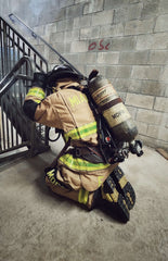 Firefighter Erik Vidal  taking a quick break to catch his breath after performing flights of stairs in full turn out gear, on air.