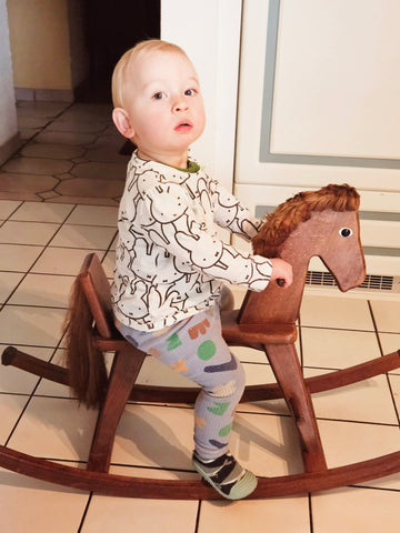 Toddler on a wooden rocking horse that his mum had used as a child
