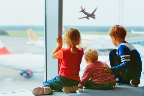 Kids watching a plane take off at the airport