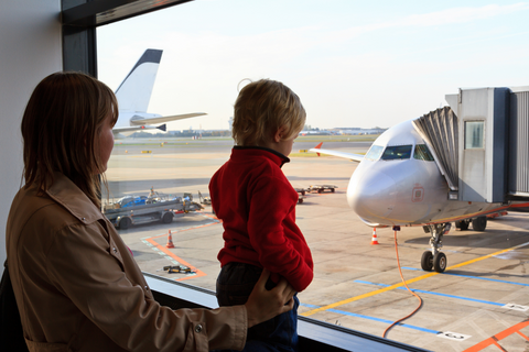 Parent and child watching a plane at the airport