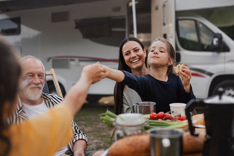 A family sitting outside their caravan in a caravan park in new south wales