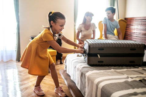 Girl unpacking her suitcase at the hotel
