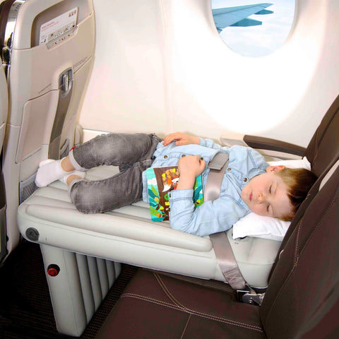 Child sleeping on inflatable seat extender on plane