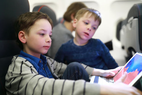 Kid on plane with tablet