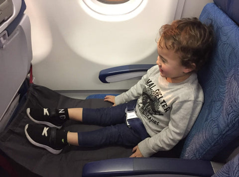Toddler using an airplane hammock on the plane