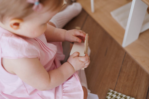 A toddler playing with wooden Montessori toys