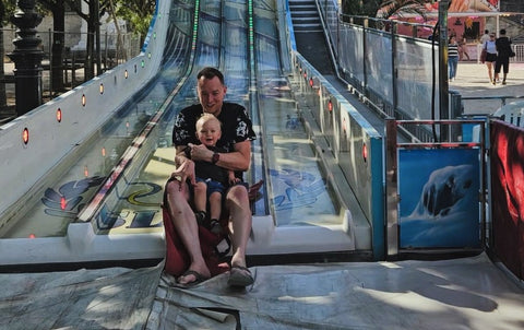 Toddler with his dad on a slide in Paris