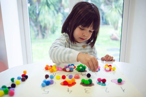 A small child playing with felt balls Montessori Toys