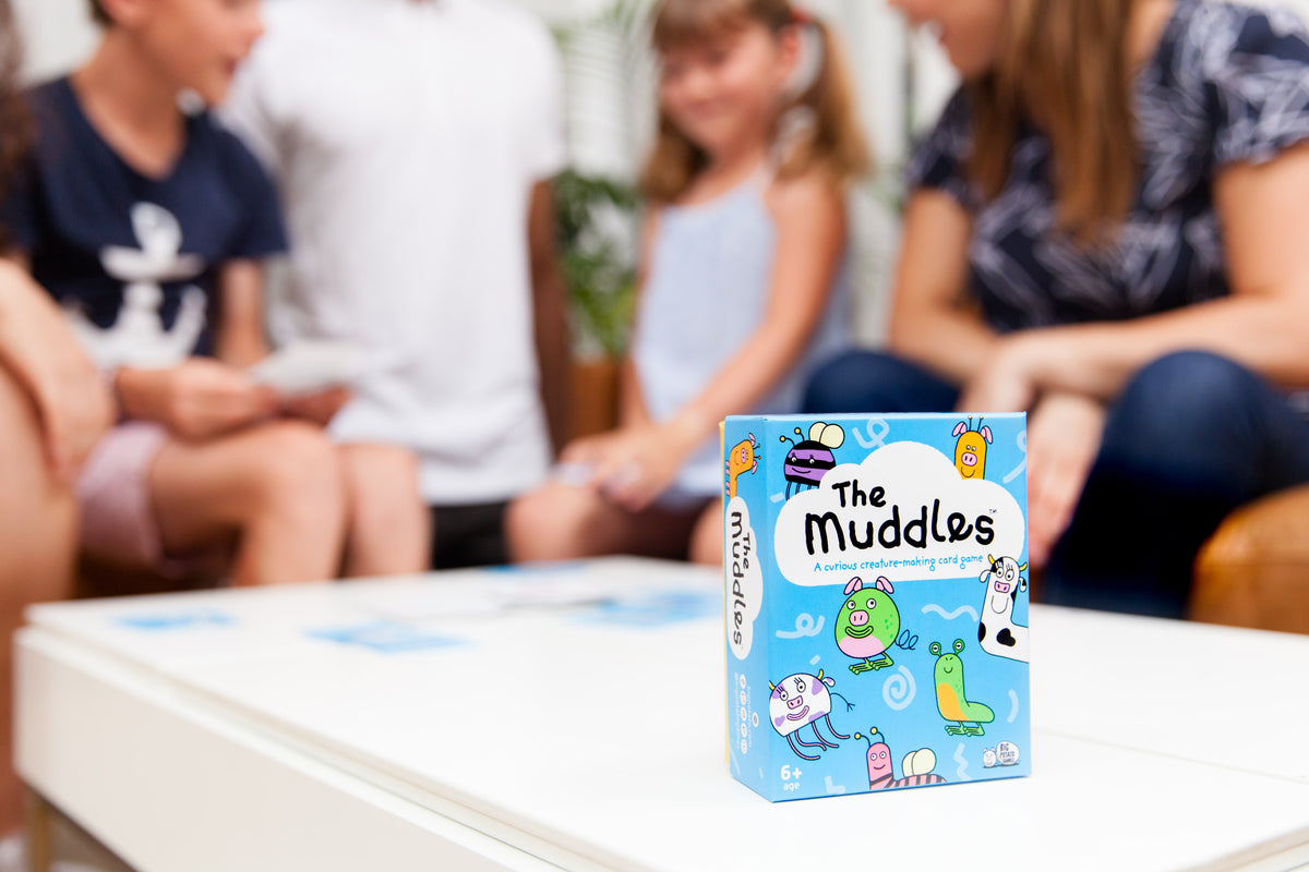 The Muddles game box with people playing in background