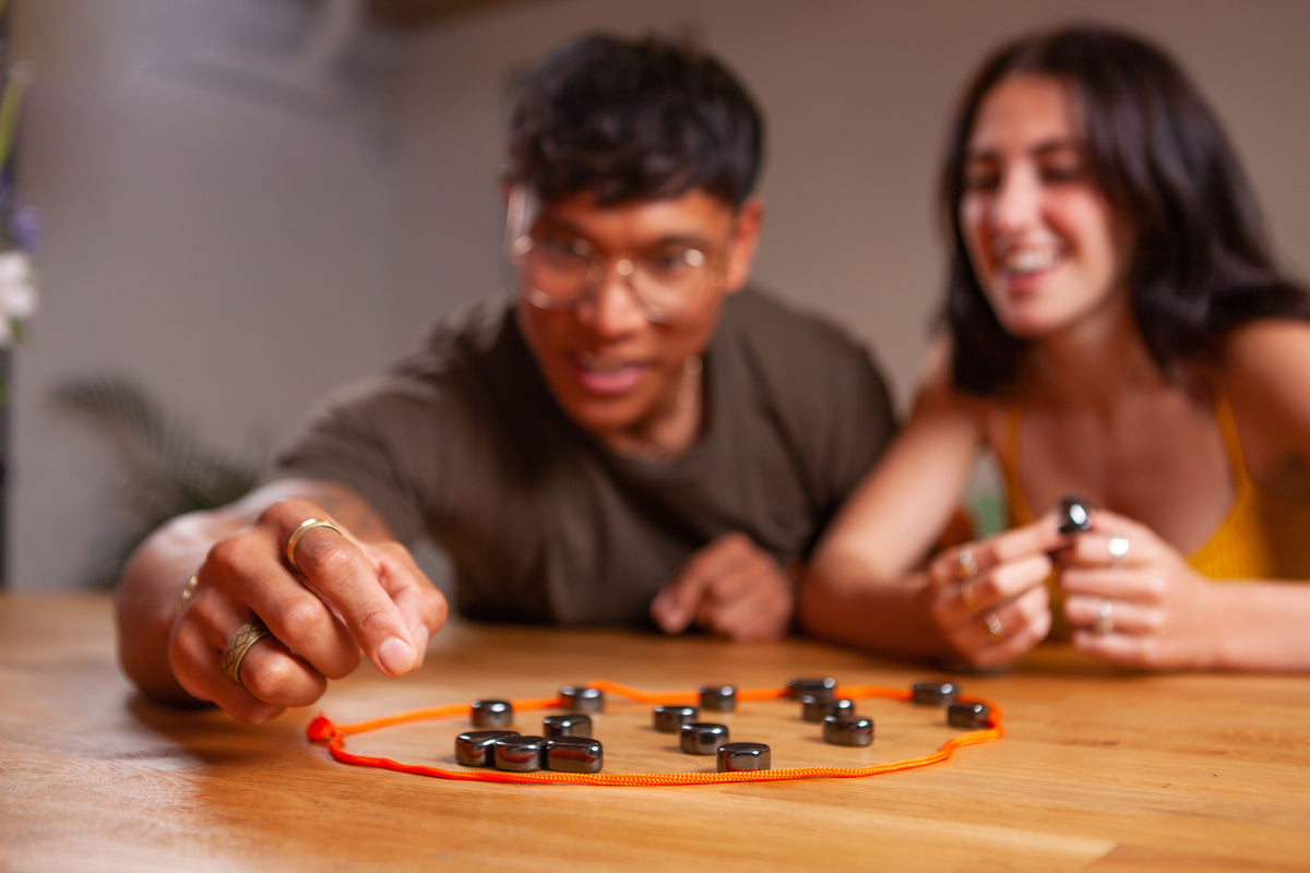 Man putting down magnet into rope circle with other magnets