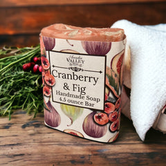 Cranberry & Fig handmade soap in a paper wrapper on a bathroom counter.