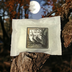 Raven Wax Melts in a tree branch at night with a full moon in the background