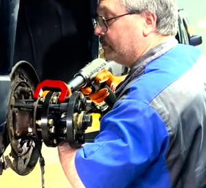 Technician using Tommy Wheel Puller to remove bearing.