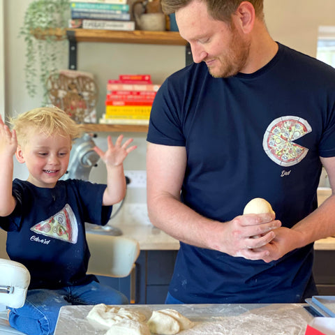 Father and son making pizza together