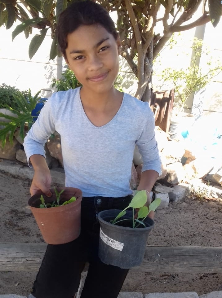 A girl is holding her new plants very proud