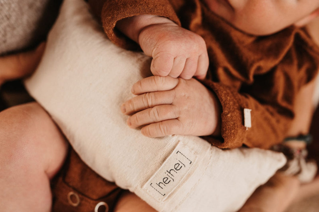 hejhej grape seed pillow in small little baby hands