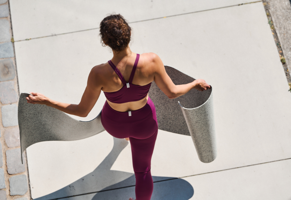Eine Frau trägt pinke Yoga Kleidung und läuft mit der eher hellen hejhej-mat