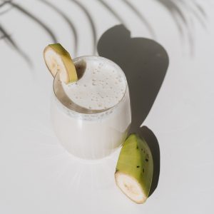 Banana smoothie with palm shade background