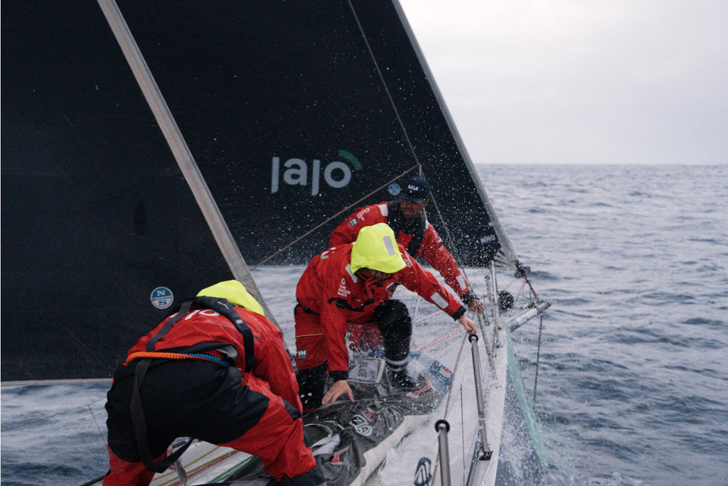 Members of Team Jajo, wearing Dubarry Crosshaven Sailing Boots, working on the boat during a race.